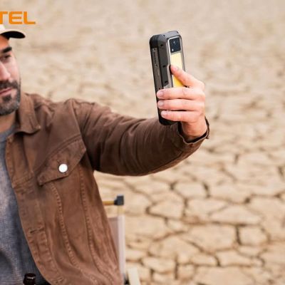 Hombre utilizando el móvil rugerizado Oukitel WP100 en un entorno desértico y árido.