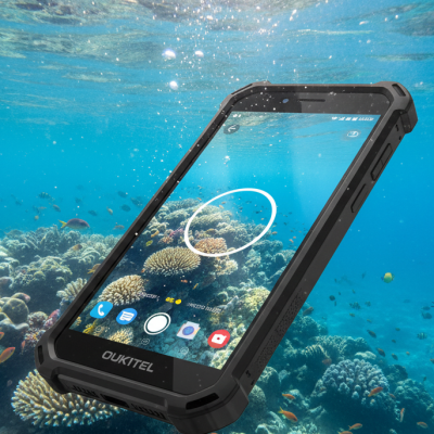 Smartphone Oukitel WP60 sumergido en agua cristalina realizando una fotografía subacuática de arrecifes.